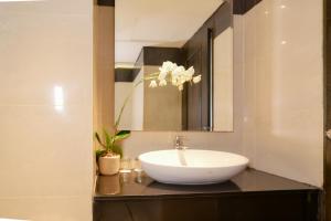 a bathroom with a white sink and a mirror at Samala Hotel Jakarta Cengkareng in Jakarta