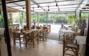 バンラック・ビーチにあるP & T Hostelのテーブルと椅子、パティオ付きのレストラン