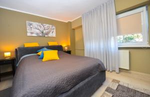 1 dormitorio con 1 cama con almohadas amarillas y azules en Romana Lahovary Studio en Bucarest