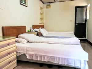una camera con tre letti e un comò di Xia Xing Inn a Jinhu