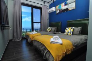 two beds in a room with a view of the ocean at Saipan Skyline Designers Hotel in Saipan