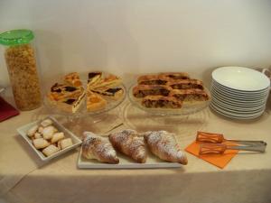 une table recouverte de assiettes de pâtisseries et de tartes dans l'établissement Cortecoraman, à Sommacampagna