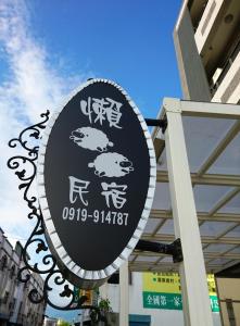 a sign with asian writing on it in front of a building at 懶羊羊民宿Cozy Sheep in Chishang