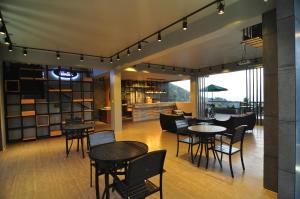 a restaurant with tables and chairs in a room at Saipan Skyline Designers Hotel in Saipan