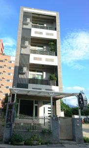 a tall building with a fence in front of it at 懶羊羊民宿Cozy Sheep in Chishang