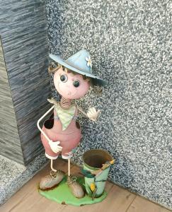 a figurine of a girl wearing a hat next to a bucket at 懶羊羊民宿Cozy Sheep in Chishang