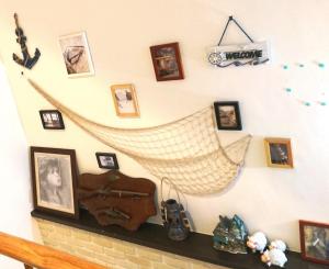a shelf with pictures and a hammock hanging on a wall at 懶羊羊民宿Cozy Sheep in Chishang