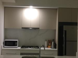 a kitchen with a microwave and a stove top oven at Hurstville New apartment with city view in Sydney
