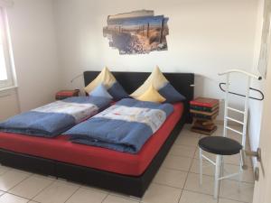 ein Schlafzimmer mit einem roten Bett mit blauen Kissen und einer Leiter in der Unterkunft Haus Nordland in Langeoog