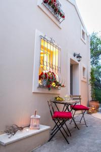 een patio met een tafel en stoelen en een raam bij lianelia boutique village house in Argyrádes