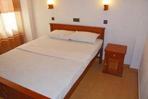 a small bedroom with a bed and a night stand at Villa Chaya in Hikkaduwa