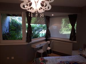 a bedroom with a chandelier and two windows at B&B Uccle in Brussels