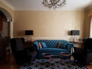 GoldStar Luxury Old Town Krakow Apartment في كراكوف: غرفة معيشة مع أريكة وكراسي زرقاء