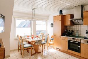a kitchen with a table and chairs in a kitchen at Haus Nordland in Langeoog