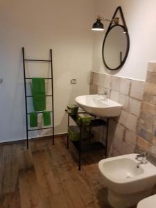 La salle de bains est pourvue d'un lavabo, de toilettes et d'un miroir. dans l'établissement Appartamento urban, à Custonaci