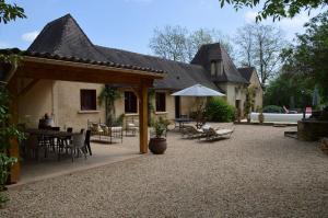 una casa con patio arredato con tavolo e sedie di Les Deux Tours a Siorac-en-Périgord