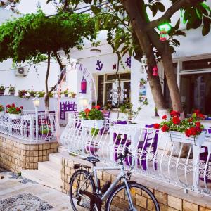 a bike parked in front of a building with flowers at Agan Pension in Bodrum City