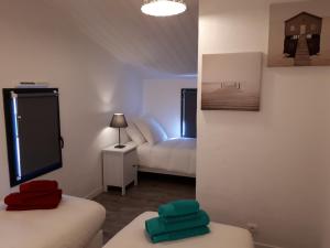 La GuérinièreにあるLa Cabane Manonのベッド2台とソファが備わる小さな客室です。