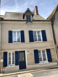 an old house with blue shutters on a street at Villa Mary in Amboise
