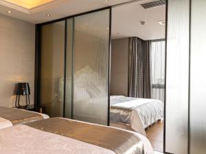 a hotel room with two beds and a glass wall at Pengman Beijing Rd. A-mall Apartment in Guangzhou