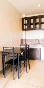 a kitchen with a black table and chairs at Veranda Residence Inn in Tacloban