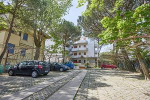 a group of cars parked on a street with trees at Residence Piccolo in Milano Marittima