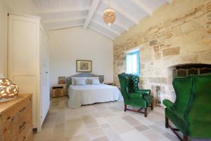 サルヴェにあるMasseria Fano Relais & Wineのベッドルーム1室(ベッド1台、緑の椅子2脚付)