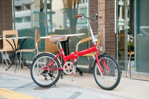 a red bike parked in front of a building at Eins.Inn Umeda Higashi in Osaka