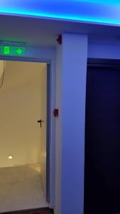 Cette chambre est dotée d'une lumière bleue et d'une porte avec un panneau. dans l'établissement Breeze Boutique Athens, à Athènes
