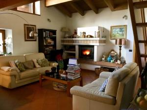 ein Wohnzimmer mit 2 Sofas und einem Kamin in der Unterkunft B&B Ai Castagni in Tenno