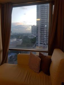 a couch sitting in front of a large window at Eton Baypark in Manila