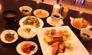 a table with plates of food on a table at Hotel Peacely In Miyakojima Nexus in Miyako-jima
