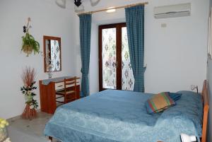 sypialnia z łóżkiem, biurkiem i oknem w obiekcie villa damecuta B&B w mieście Anacapri