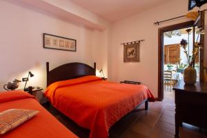 a bedroom with two beds with orange sheets at Relais Le Nereidi in San Vito lo Capo +62 photos