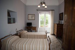 a bedroom with two beds and a window at B&B Valle Allegra in Gravina di Catania