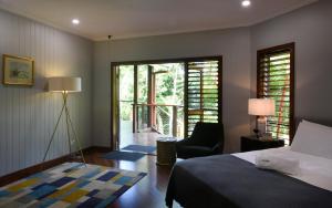 a bedroom with a bed and a chair and a balcony at Sealords in Mission Beach