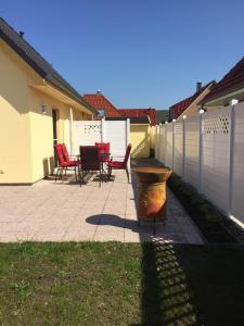 a patio with chairs and a table and a fence at Ferienhaus Arielle in Glowe