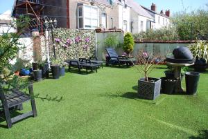 a garden with chairs and potted plants on the grass at Brincliffe Hotel in Blackpool