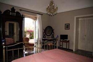 a bedroom with a bed and a chandelier at B&B Valle Allegra in Gravina di Catania