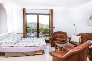 salon z łóżkiem i skórzanymi krzesłami w obiekcie Apartma Barbara w Koprze