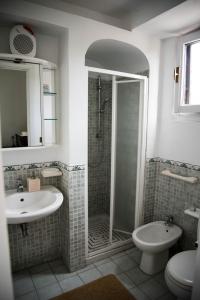 bagno con doccia, lavandino e servizi igienici di B&B Valle Allegra a Gravina di Catania