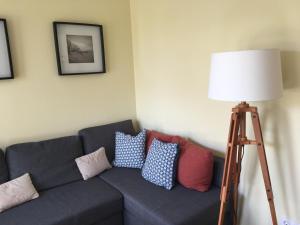 ein Wohnzimmer mit einem Sofa mit Kissen und einer Stehlampe in der Unterkunft Villa Cosima in Bansin