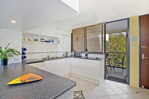 a kitchen with a yellow surfboard on a counter at Beachpark 56 58 Pacific Drive in Port Macquarie
