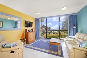 een woonkamer met 2 banken en een groot raam bij Beachpark 56 58 Pacific Drive in Port Macquarie