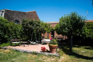 a garden with a building with a table and chairs at B&B Valle Allegra in Gravina di Catania