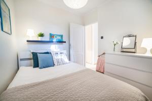 1 dormitorio con 1 cama grande con almohadas azules en Apartments Dexter Warsaw by Renters, en Varsovia