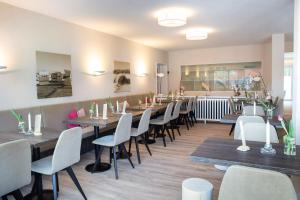 um restaurante com mesas e cadeiras em uma sala em Hotel Twilling em Böhl