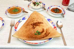 una mesa con un plato de sopa y una tostada en Ramoji Film City- Tara Comfort Hotel, en Pedda Ambarpet