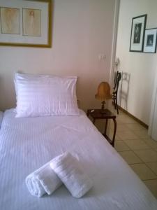 a white bed with two towels on top of it at Corfu Retreat in Corfu