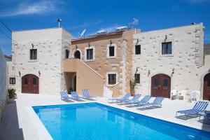 a villa with a swimming pool in front of a building at Villa Cardia in Kiriánna